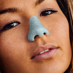 Load image into Gallery viewer, A girl looking up at the screen and wearing noz blue sunscreen
